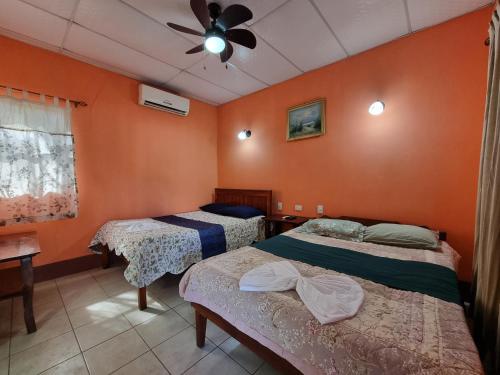 莫约加尔帕Ometepe House的橙色墙壁客房的两张床