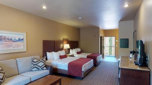 塞多纳Sedona Real Inn & Suites的酒店客房,配有床和沙发