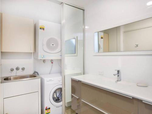 黄金海岸Maimi renovated 2-bedroom apartment的白色的浴室设有洗衣机和水槽。