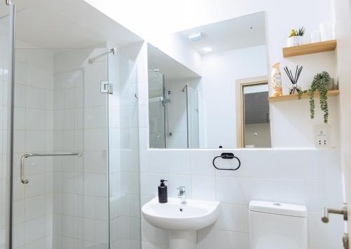 阿克拉Luxury Studio Suite at The Gallery的白色的浴室设有水槽和淋浴。