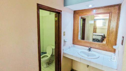 墨西哥城Hotel Plaza San Juan的一间带水槽、卫生间和镜子的浴室