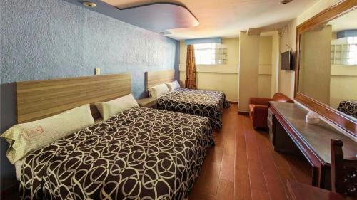 墨西哥城Hotel Plaza San Juan的酒店客房,设有两张床和镜子