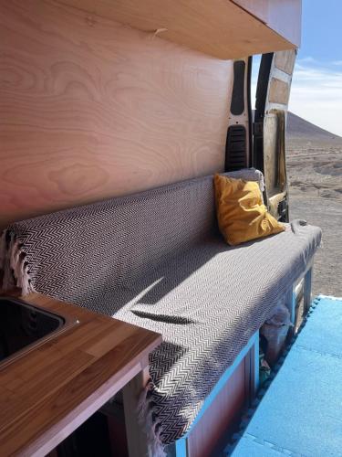 Charco del PinoCampervan for family的一张沙发,放在带枕头的货车后面