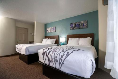 默特尔比奇Sleep Inn near Outlets的酒店客房,配有两张带白色床单的床