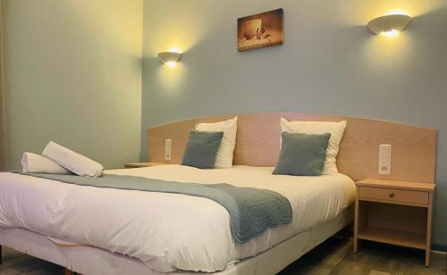 埃苏瓦Hôtel Les Demoiselles的一间卧室配有一张大床和两个枕头