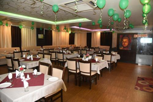 维沙卡帕特南Hotel green apple的一间设有白色桌子和绿色气球的用餐室