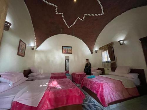 阿斯旺Maghrabi's Guest house的一位妇女站在带两张床的房间