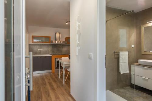 奈维斯Apartments and rooms with parking space Njivice, Krk - 17010的带淋浴、盥洗盆和桌子的浴室
