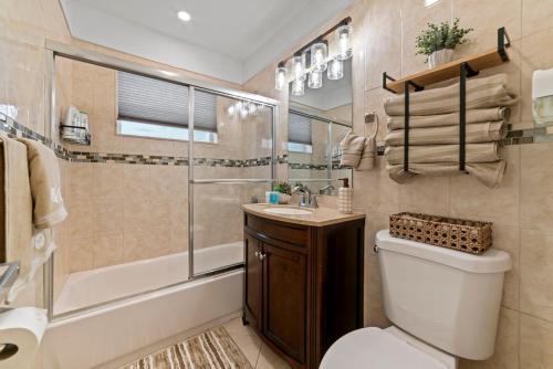 西棕榈滩Paradise Villa!!! Heated Pool, Games,10 min to Palm Beach & Airport的浴室配有卫生间、淋浴和盥洗盆。