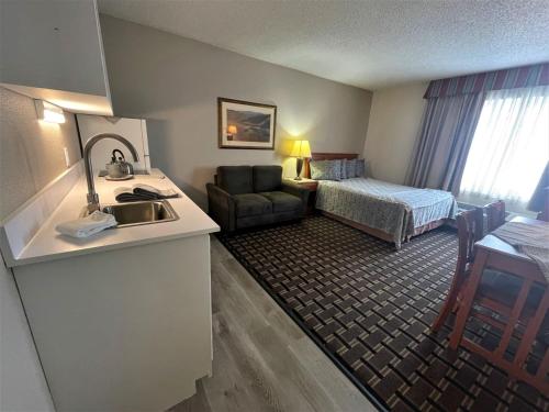 爱达荷福尔斯FairBridge Extended Stay, a Kitchenette Hotel的酒店客房设有水槽和一间卧室