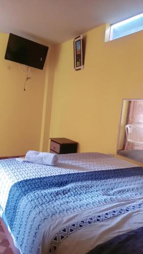 阿亚库乔Hospedaje PARAISO的一间卧室配有一张带蓝色毯子的床