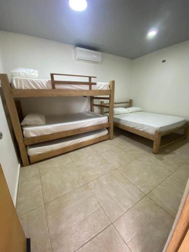SabanagrandeCABAÑA LUJOSA CON MESA DE BILLAR的客房设有两张双层床,铺有瓷砖地板。