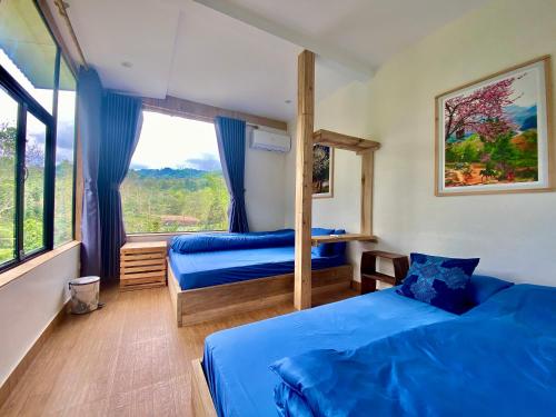 河江Ha Giang Xanh Retreat, Tour and Motorbike Rental的一间卧室设有两张床和大窗户