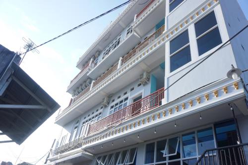 肯达利OYO 93773 Pondok Bintang的白色的建筑,旁边设有阳台