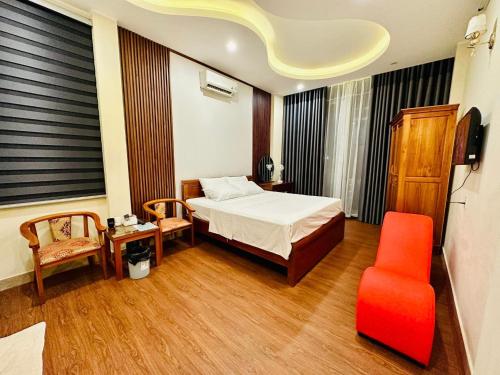 Tuyên QuangTuan Anh Hostel的一间卧室配有一张床和一张红色椅子