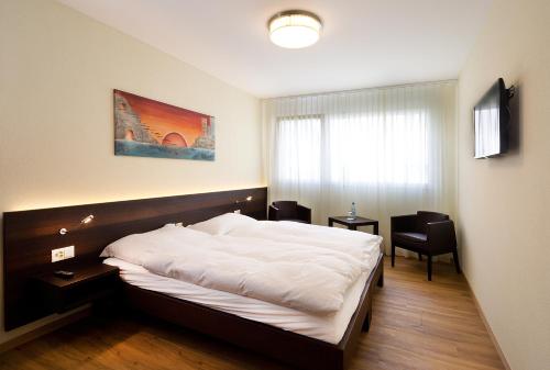 格朗格拉尼斯酒店的一间卧室配有一张床、两把椅子和一个窗户