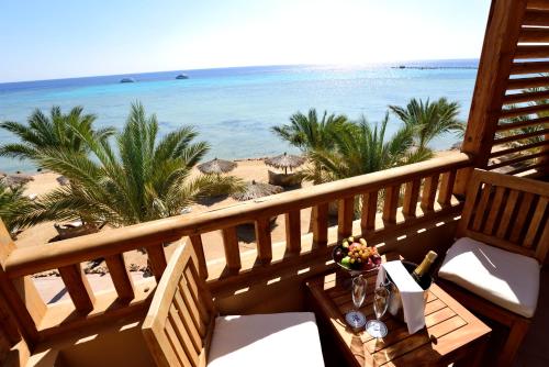 赫尔格达索马湾破浪者潜水与冲浪酒店的阳台配有桌子,享有海滩美景
