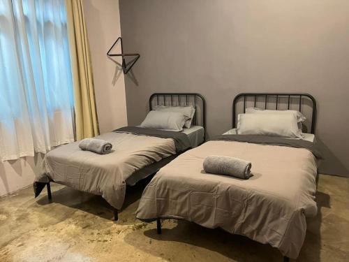 古达JW Homestay (ShopHouse Lv2)的两张睡床彼此相邻,位于一个房间里