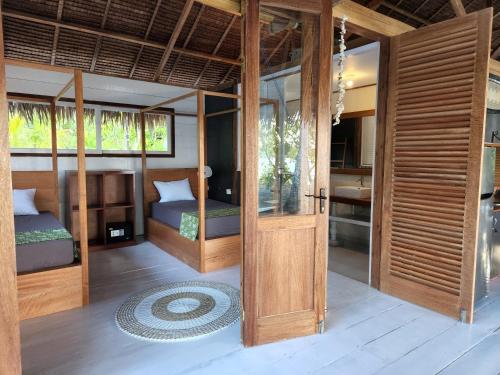 Tua PejatLeleu Mentawai Accommodation的一间设有两张床和一扇门的房间