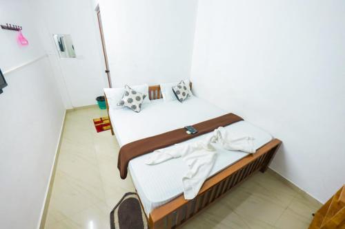埃尔讷古勒姆SIYA RESIDENCY的一间卧室配有带白色床单和枕头的床。