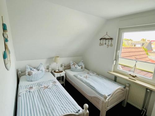 诺德代希Ferienwohnung Joanna的带窗户的客房内设有两张单人床。