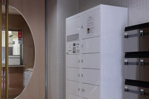 大阪yksi STAY ＆ APARTMENT OSAKA的浴室设有白色橱柜和镜子