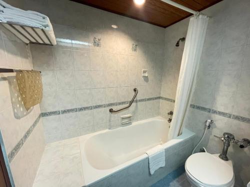 清莱旺克姆酒店的浴室配有白色浴缸和卫生间。