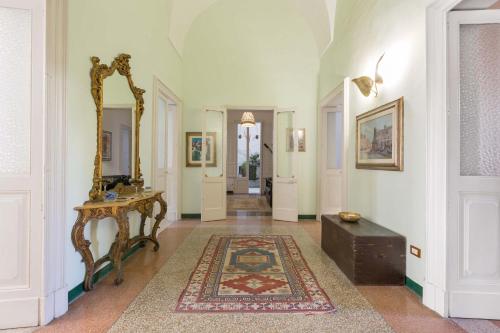 莱切Dongiovanni Suite的走廊上设有镜子、桌子和地毯