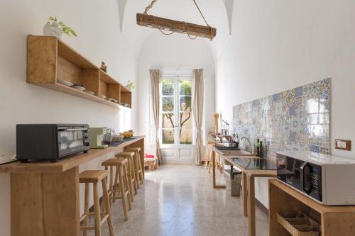 莱切Dongiovanni Suite的厨房配有木制台面和木凳