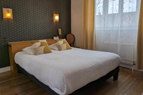 蒙特普利斯尚伯德Logis Hôtel Le Saint Florent的一间卧室配有一张带白色床单的床和一扇窗户。