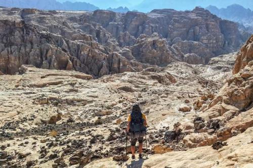 达纳Adventure camping - Organized Trekking from Dana to Petra的站在峡谷边缘的人