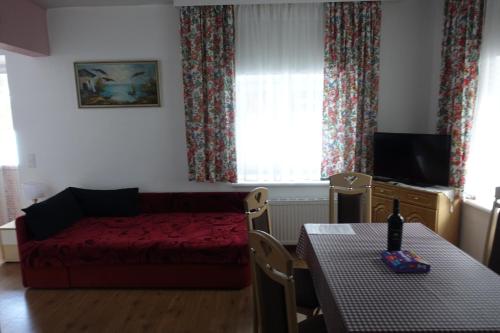 KirchbachApartmenthaus Kestel的客厅配有红色的床和桌子