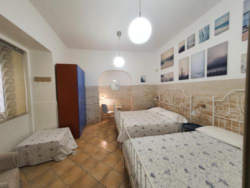 卡尔塔吉罗Trio D'Archi - La Maison de Cocò的一间卧室配有三张床和一张桌子及椅子