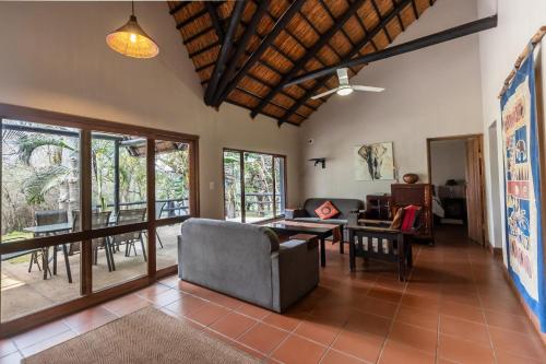 焦济尼Ndumu River Lodge的客厅配有沙发和桌子