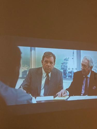 诺维萨德Hostel Stari Grad的电视屏幕,两个男人坐在桌子上