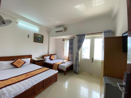 头顿Ngoc dung MoTel的酒店客房,设有两张床和一张沙发