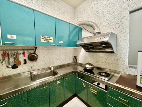 马公澎湖菊舍民宿一館的厨房配有绿色橱柜和水槽