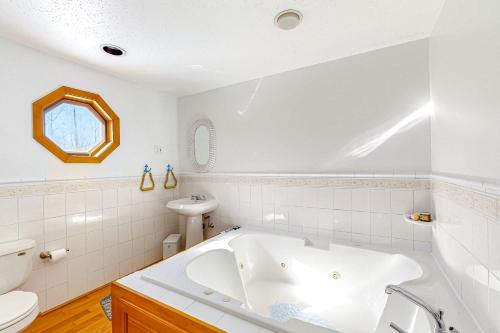Owls HeadSerenity Now & Ever的白色的浴室设有浴缸和水槽。