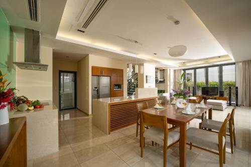 岘港Blue Sky & Villas Beach Resort的厨房以及带桌椅的起居室。