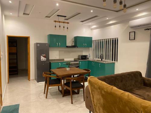 科托努Residence SIRTAK的厨房配有绿色橱柜、桌子和沙发