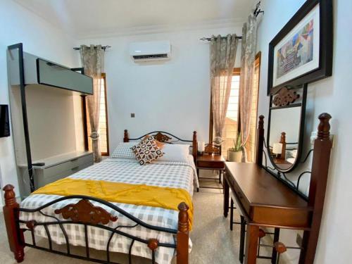 KwashiemanInviting 3-Bed House in Awoshie Accra的一间卧室配有一张床、一张桌子和一张四柱床。