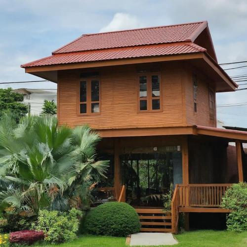 Ban Bung Rua Yaiบ้านเจ้าสัวน้อย的一座大型木房子,设有红色屋顶