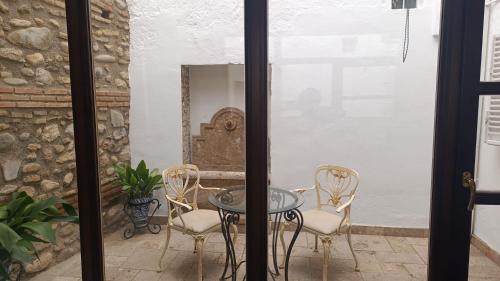 格拉纳达Suite Comares的一个带玻璃桌和椅子的庭院