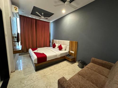苏拉特Hotel Dumas Near Airport的酒店客房,配有床和沙发
