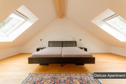 锡默拉特Rurtal de luxe的阁楼卧室设有1张床和2扇窗户