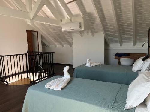 Oyster PondColombus Résidence的一间设有两张床的房间,上面有天鹅