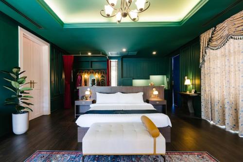 华欣华欣海魁特花园酒店的一间设有白色床和绿色墙壁的大卧室