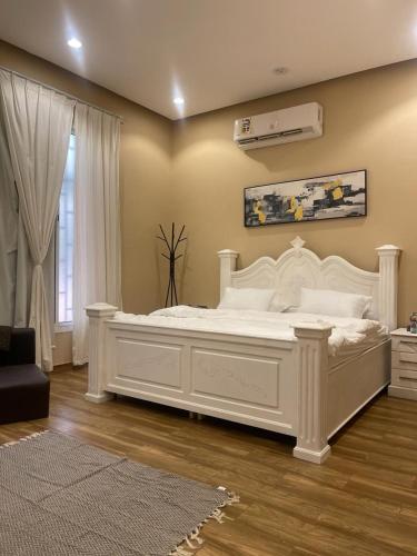 Madain Salehمزرعة المدائن的窗户客房内的一张大白色床