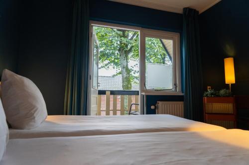 奥特罗Ontbijthotel Kruller的一间卧室设有一张大床和一个窗户。