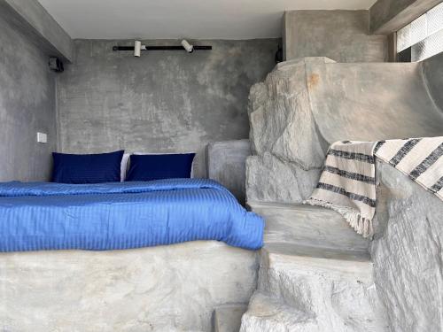 马特莱Three Creeks Matale的一间卧室配有一张带蓝色枕头的床
